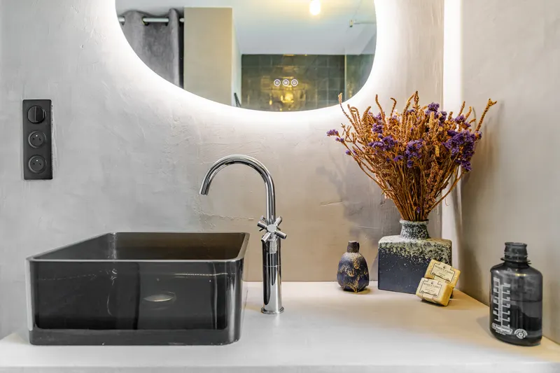 Salle de bain design avec vasque noire dans un appartement géré à Strasbourg